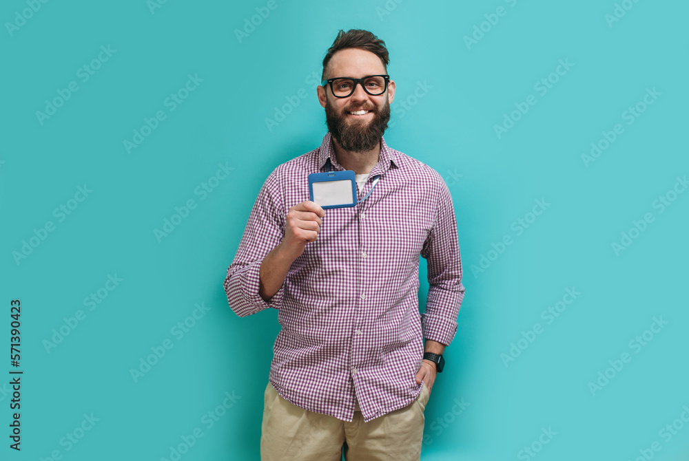 Fototapeta premium Young caucasian man with a beard in glasses for vision with a blank badge isolated on a blue color background