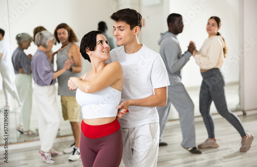 Dancing positive couples learning salsa in a dance school lesson