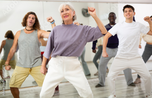 Energetic elderly lady attending group choreography class  learning modern dynamic dances. Concept of active lifestyle of older generation..