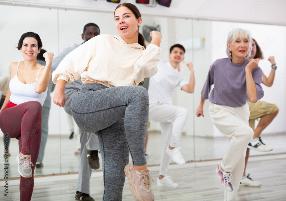 Fototapeta premium Active people of different nationalities learn sports dancing at a group class in a dance studio