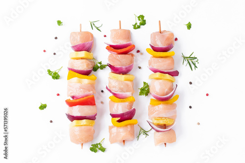 Raw pieces of chicken skewers with pepper onion and pineapple on a white background.Uncooked mixed meat skewer with peppers.Skewers with pieces of raw meat, red, yellow and green pepper.Top view. photo