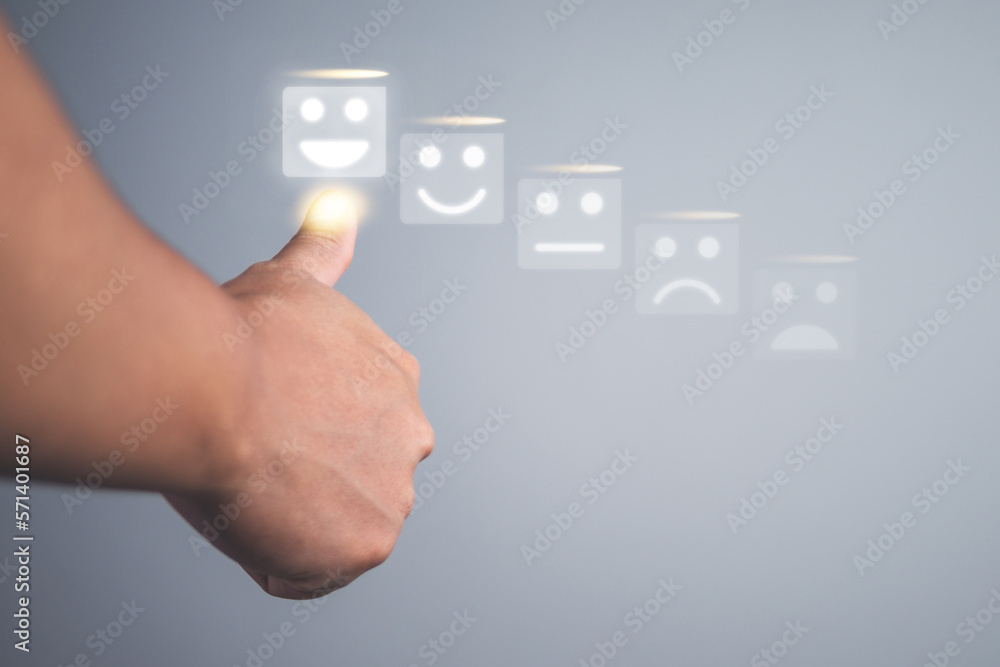 Someone shows thumbs up. Evaluation concept. He chooses a grin face that shows excellent job and best service for customer review. POV shot with copy space. Someone shows thumbs up. Evaluation concept. He chooses a grin face that shows excellent job and best service for customer review. POV shot with copy space.