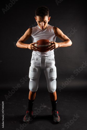 Youth Preteen Boy Football Player Holding Football in Studio