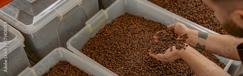 Male business owner hands demonstrate freshly roasted coffee beans