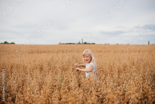 6 year old girl running in a wheat field. Happy childhood concept