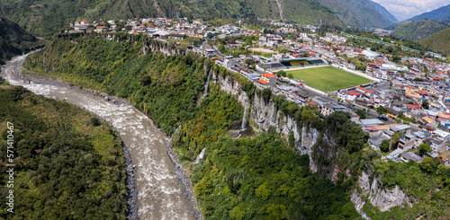 Aerial view over banos with two small waterfalls visible over the cliff separating the village with the Pastaza river