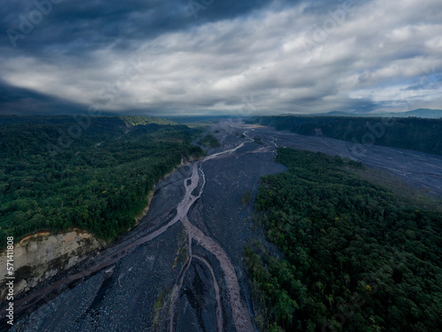 Aerial view of a meandering river named Upano in the foothills of the Andes in Ecuador, beautiful background of a river with a broad riverbed surrounded by steep cliffs
