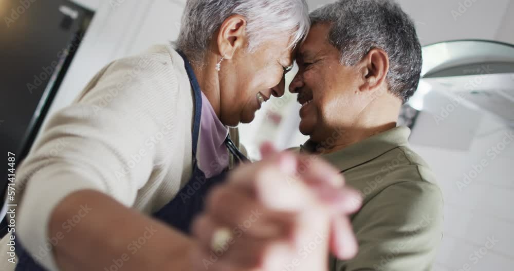 Happy senior biracial couple dancing in kitchen Happy senior biracial couple dancing in kitchen