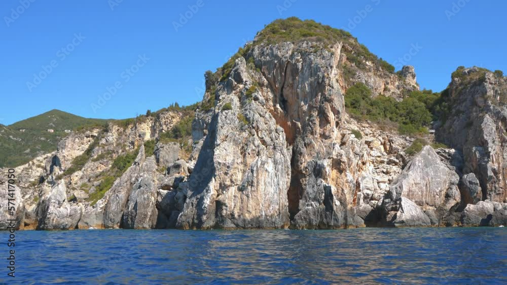 Sharp tall rocky cliffs visible above water - typical seascape near Paleokastritsa, Corfu Greece, view from a boat Sharp tall rocky cliffs visible above water - typical seascape near Paleokastritsa, Corfu Greece, view from a boat
