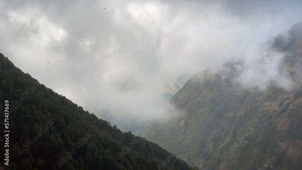 Two mountains forming a huge valley with a time-lapse of clouds flowing into the valley of the Himalaya Mountains. Two mountains forming a huge valley with a time-lapse of clouds flowing into the valley of the Himalaya Mountains.