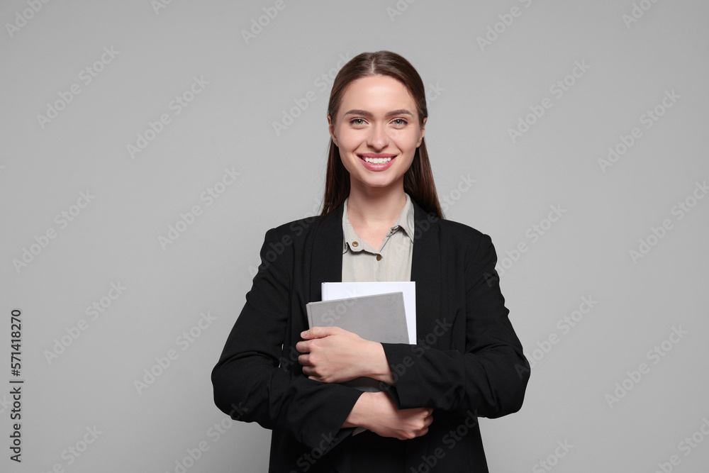 Portrait of beautiful young teacher on grey background Portrait of beautiful young teacher on grey background