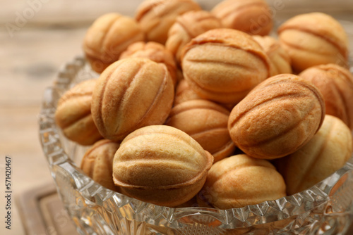 Bowl of delicious nut shaped cookies on wooden table, closeup