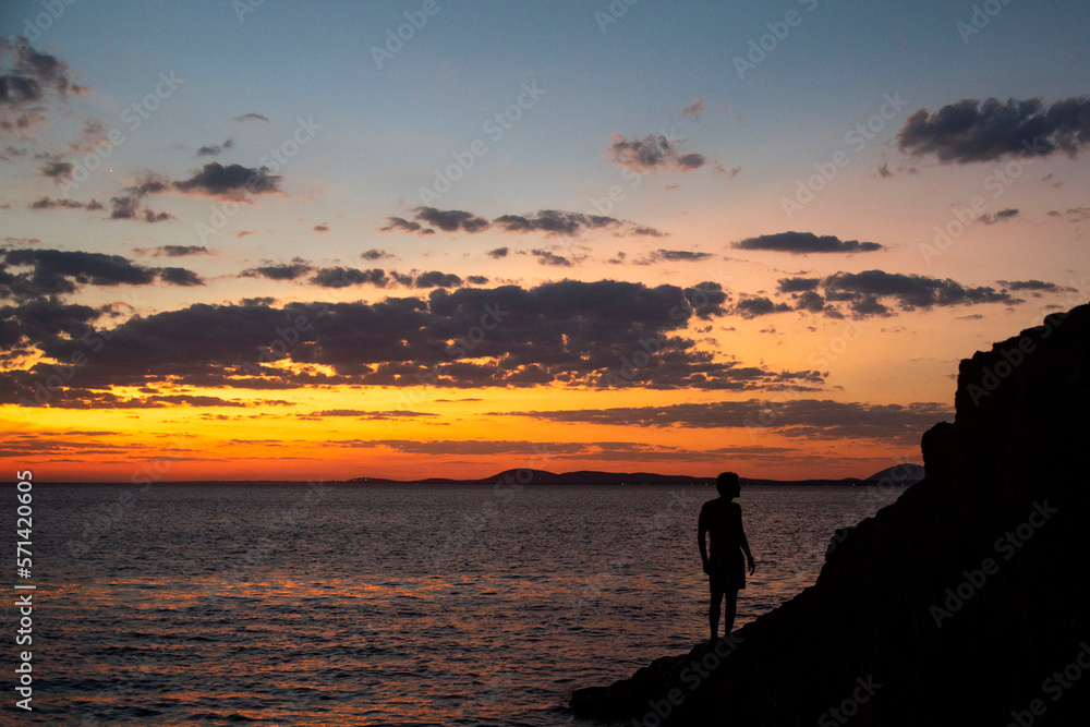 Siluetas entre las rocas al atardecer en verano