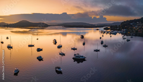 Soft and hazy aerial sunrise waterscape with boats