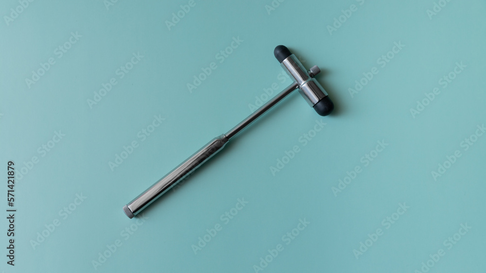 neurological hammer on a blue background. medical instrument on a turquoise background, medical equipment lies. neurological hammer on a blue background. medical instrument on a turquoise background, medical equipment lies.