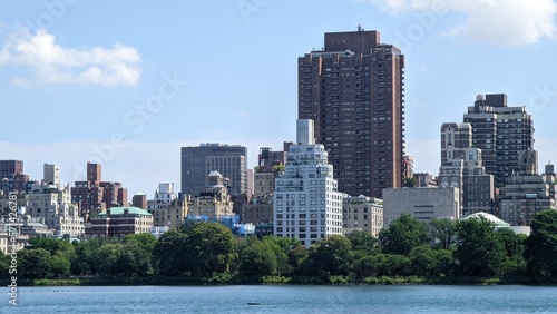 city skyline long exposure photo of a view of the city towers from the lake from the central park  in a day of spring  manhattan island  new york city nature plants and outdoors in spring season