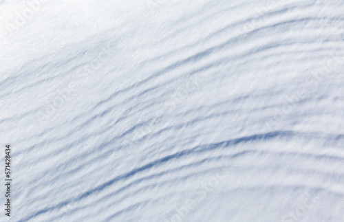 White abstract natural background of the snowy ice surface of Baikal Lake on a frosty windy day. Top view of the layered structure of the snow crust. Flat lay, copy space, mock up, blank