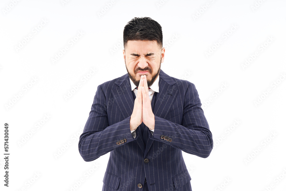 祈るポーズをするスーツ姿の男性 祈るポーズをするスーツ姿の男性
