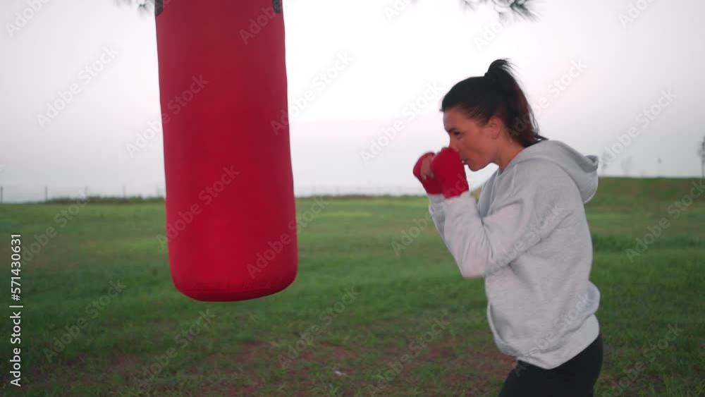 Vidéo Stock Fitness woman training boxing use punching bag outside in