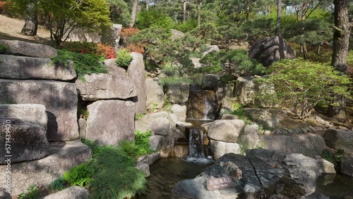 Small Waterfall Cascades On The Autumn Forest At Hwadam Botanic Garden In South Korea. Static Shot photo