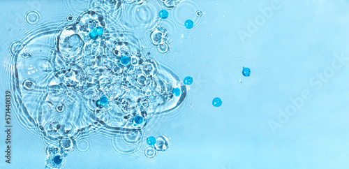 Abstract water, cosmetic background with waves and ripples and spherical granules. Concept of therapeutic moisturizing cosmetics