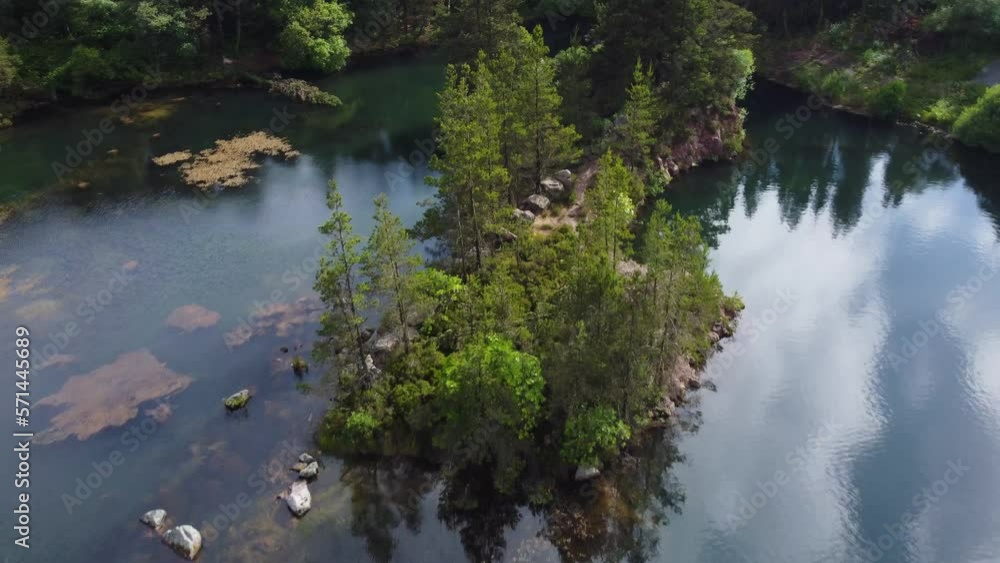 Aerial pull out of small island surrounded by water in old Irish quarry Aerial pull out of small island surrounded by water in old Irish quarry