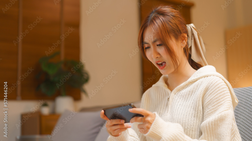 Nightlife concept, Young woman playing game on smartphone with excited in night time at winter Nightlife concept, Young woman playing game on smartphone with excited in night time at winter