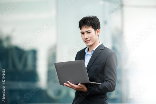 Portrait of business man holding laptop.Office worker at business center..