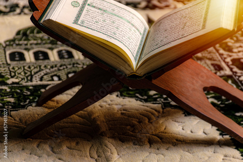 Quran in a mosque. An open Holy Quran and a muslim prayer beads on wood stand