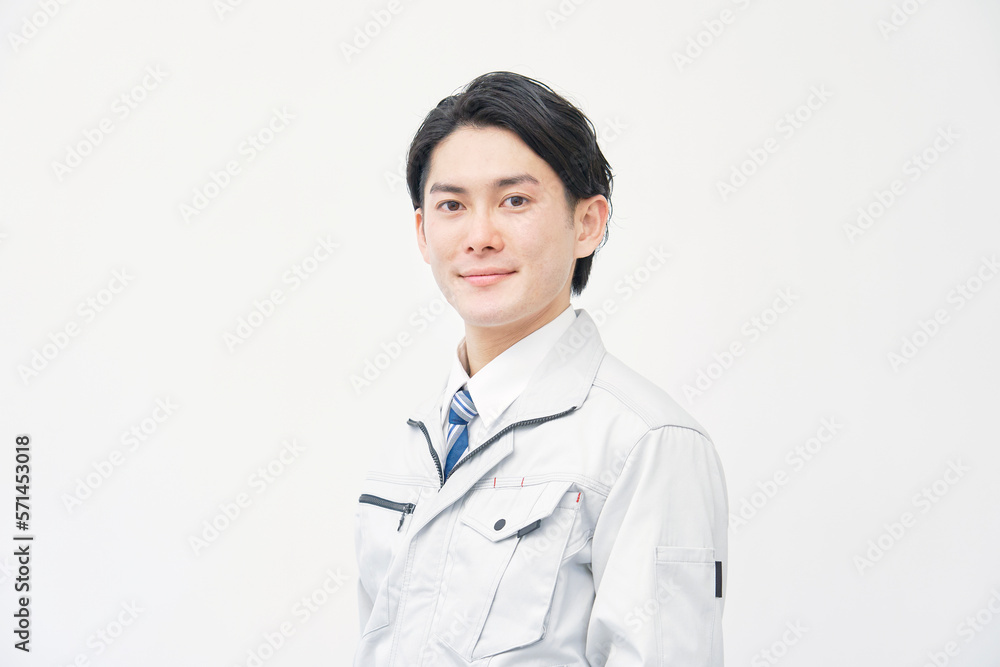 カメラ目線の作業着の男性のポートレート　白背景