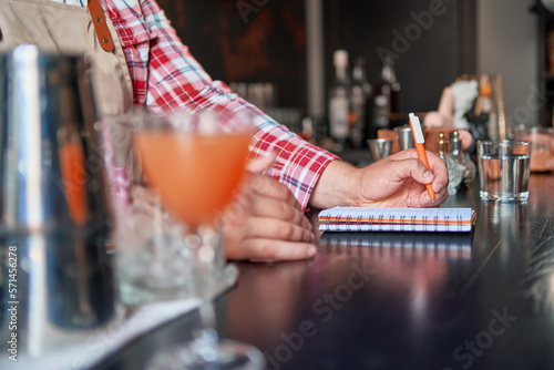 Φωτογραφία bartender standing at bar counter taking notes