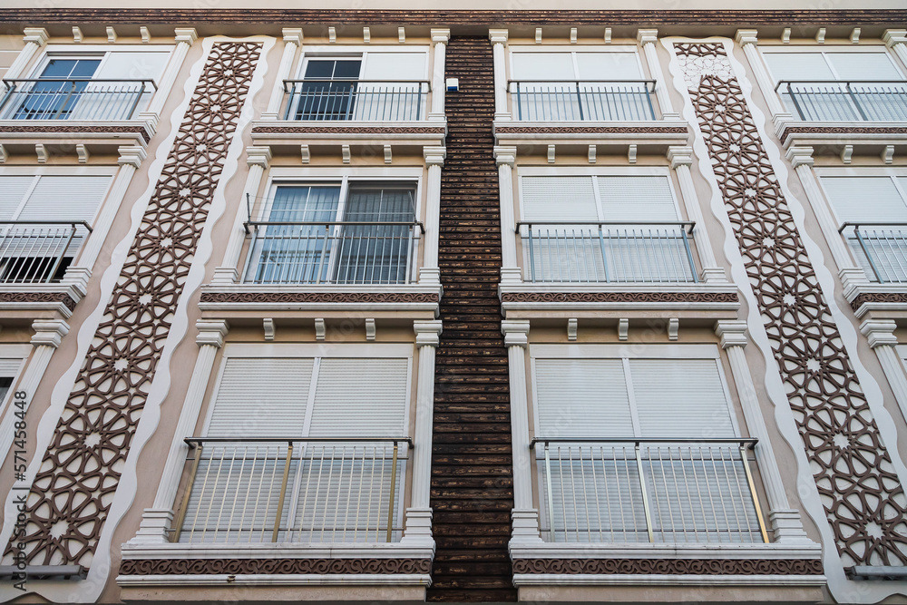 Obraz premium A gray residential building with flat, identical balconies with ripped air conditioners . Balcony pattern