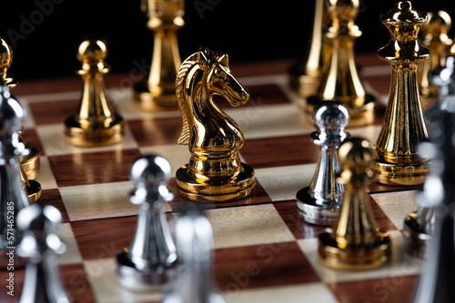 Gold and silver chess figures placed on chessboard