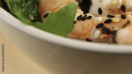 close-up of poke with shrimp, cucumber and avocado in a paper cup. Hawaiian straightfood. seafood