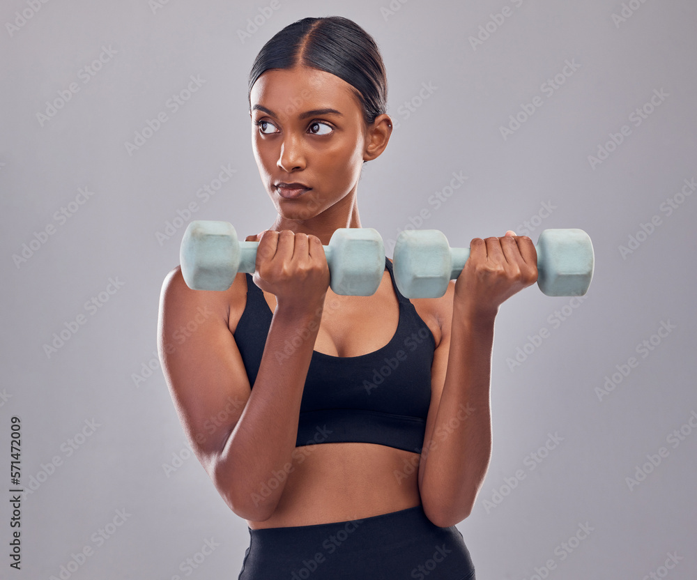 Woman, focus and dumbbell training in studio for strong body, action or thinking of mindset goals. Indian female, bodybuilder and weights of fitness, power exercise or muscle energy of sports workout Woman, focus and dumbbell training in studio for strong body, action or thinking of mindset goals. Indian female, bodybuilder and weights of fitness, power exercise or muscle energy of sports workout