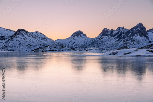 Icy Casares de Arbas reservoir and mountains with snow in winter at sunset, Leon, Spain.