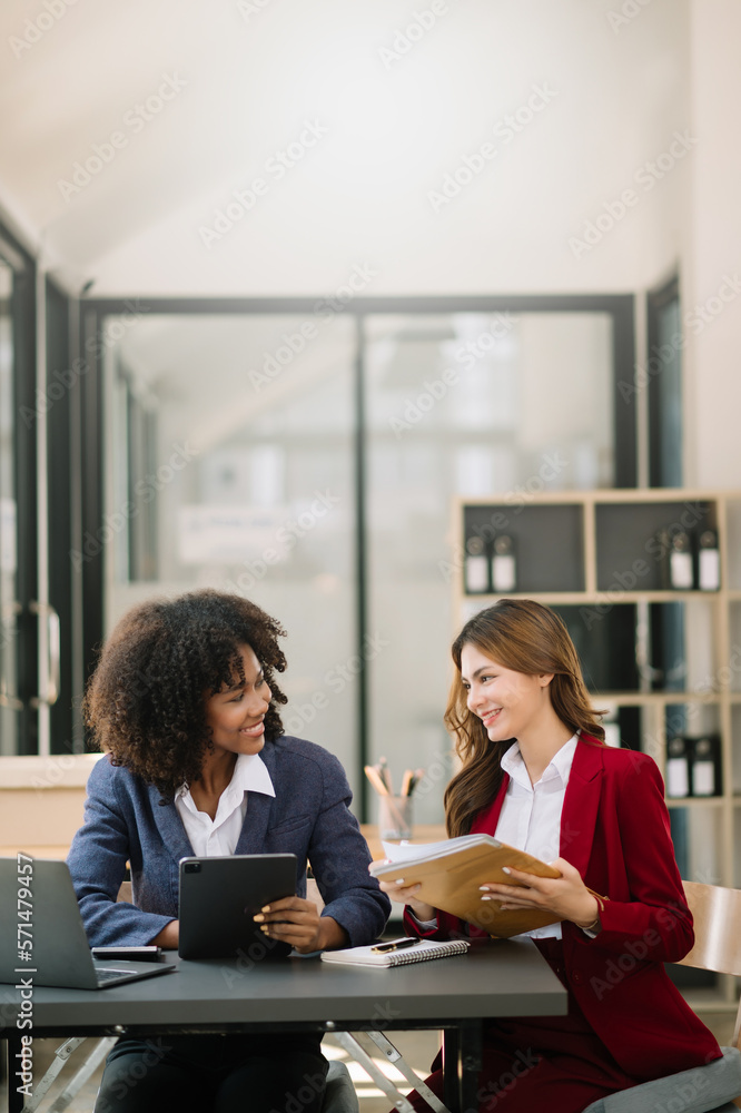 Obraz premium Two businesswoman discuss investment project working and planning strategy with tablet laptop computer in modern office..