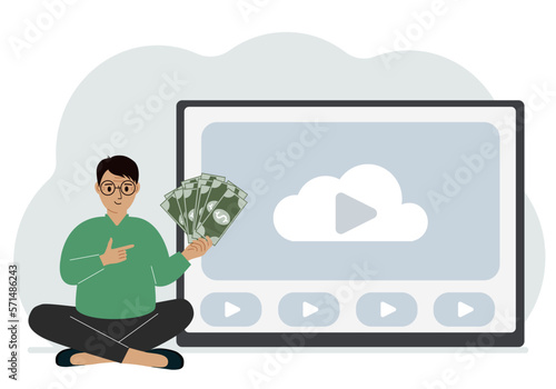 A man holds paper banknotes in his hand, next to a computer with a video. Freelancer, earning money, working on the Internet, training, coaching, business, remote work.