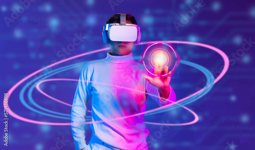 Metaverse technology concept. Man in white t shirt wearing VR headset scanning fingerprint to connect world virtual data and entertainment on blurred background..