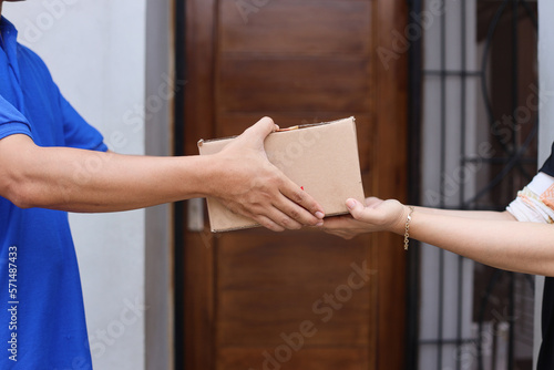 Bilde på lerret Close-up of customer receiving parcel box from delivery man - courier service concept