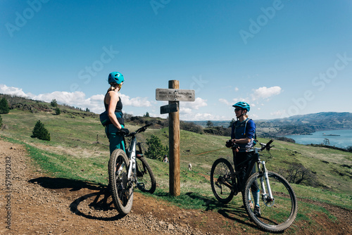 Two young women take a break while mountain biking in Washington State photo