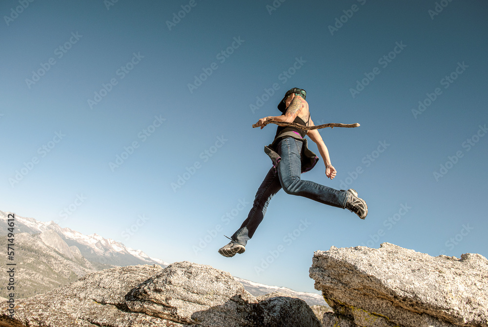 female hiker jumping rocks in yosemite female hiker jumping rocks in yosemite