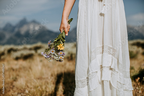 close up of bride with wildflower bouquet in front of Tetons, Wyoming photo