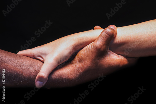 Male and female hands with different skin tones holding each other