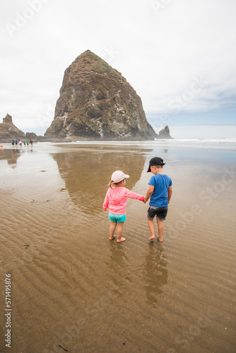 Brother and sister holding hands while at the beach. photo