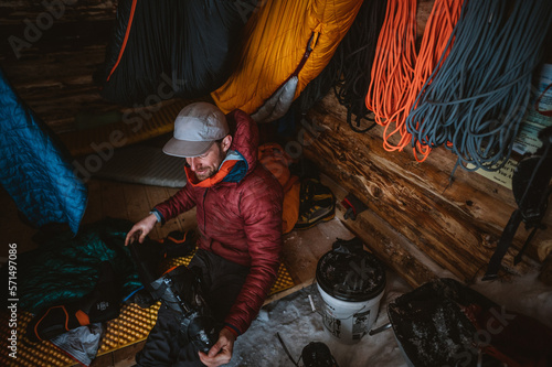 Man taking liner out of ski boot in backcountry cabin
