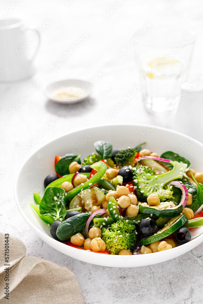 Chickpea and spinach vegan vegetable salad with broccoli, sweet pepper, olives and grilled zucchini. Mediterranean diet, healthy food Chickpea and spinach vegan vegetable salad with broccoli, sweet pepper, olives and grilled zucchini. Mediterranean diet, healthy food