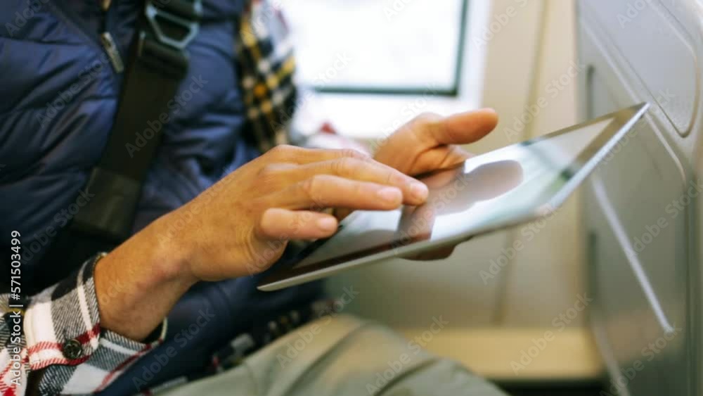 Closeup man using electronic tablet on public transit Closeup man using electronic tablet on public transit