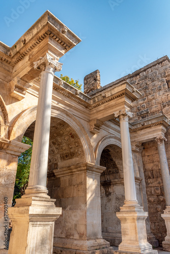 Popular tourist attraction - ancient Roman Hadrian Gate in old town Antalya (Turkey) on a summer day under the blue sky.