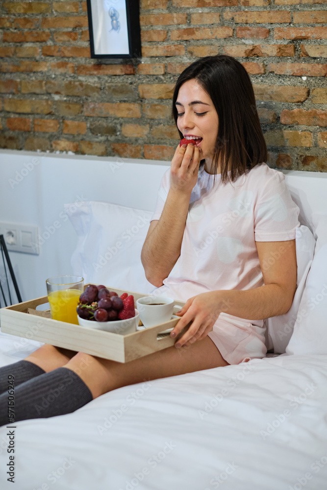 Young woman having a healthy breakfast on bed at home Young woman having a healthy breakfast on bed at home